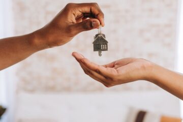 Real estate agent giving a man the keys to his new home